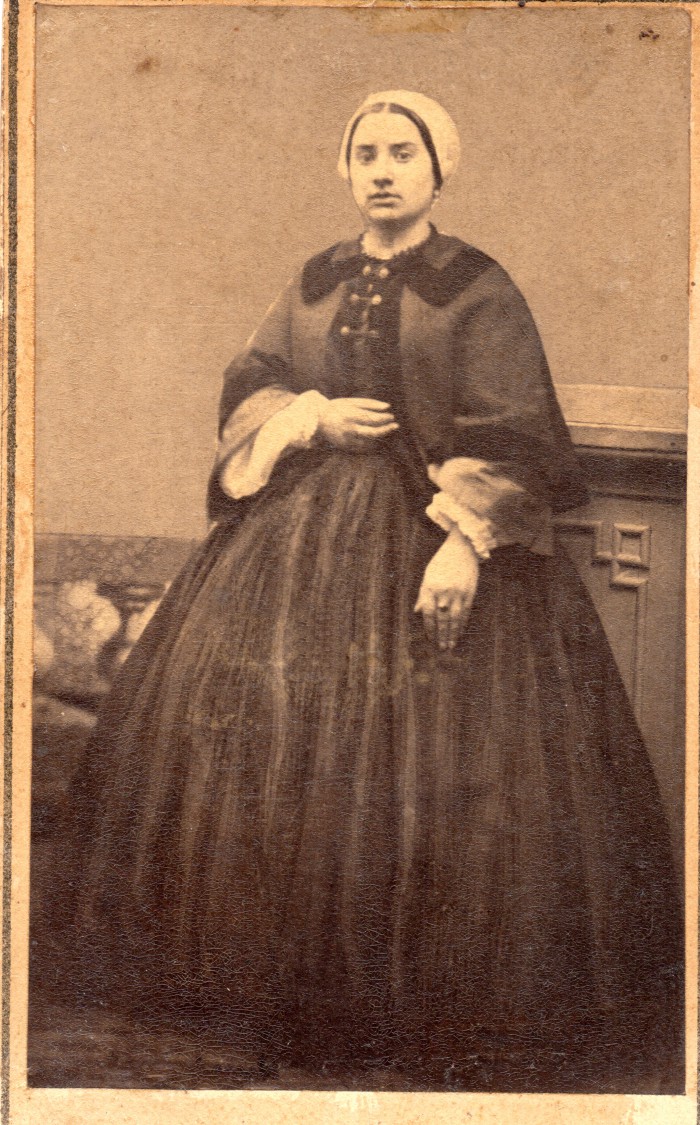Portrait de jeune femme. Une jeune Catalane portant la coiffe, en robe à crinoline. Elle porte une veste cape qui lui sert de manteau. Photo Bataille, Perpignan, vers1863, collection Institut du Grenat. 
