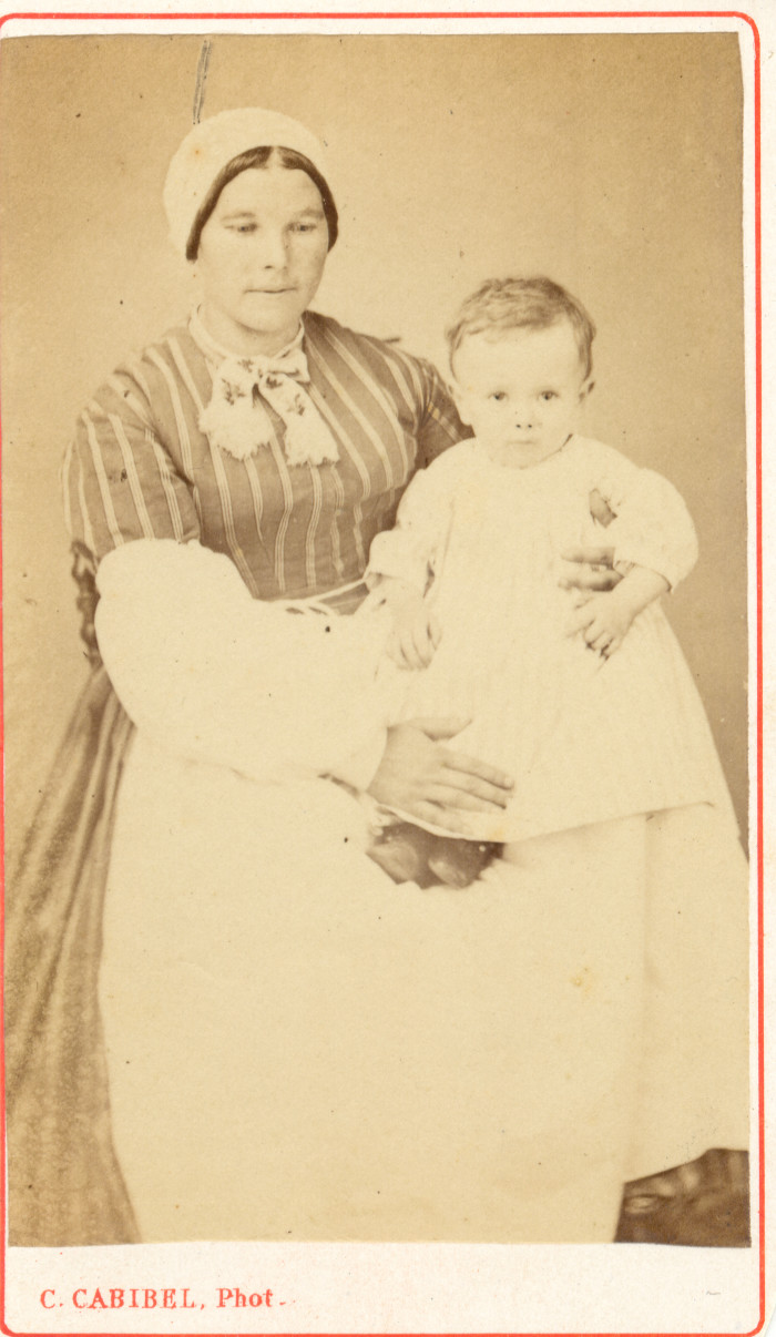 Portrait de nourrice. Cette Jeune femme porte la coiffe catalane en usage en Roussillon. Sur ses genoux repose le fils de Justin MASSOT (1828-1880), médecin et conseiller général des Pyrénées-Orientales. Photographie Cabibel, Perpignan, vers 1860, collection particulière.