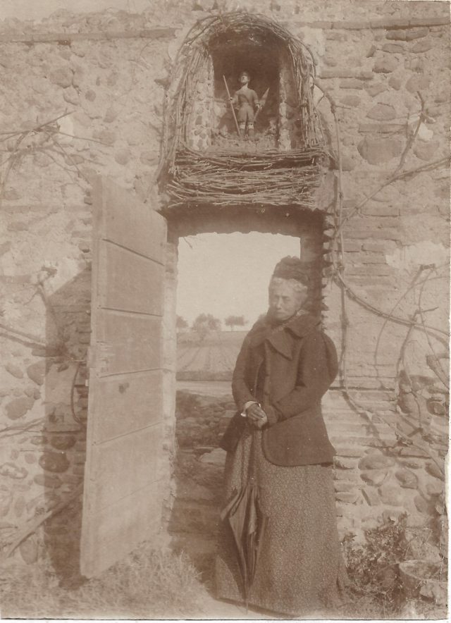 Madame Sebe à la porte du jardin sous la niche dédiée à saint Gauderique.